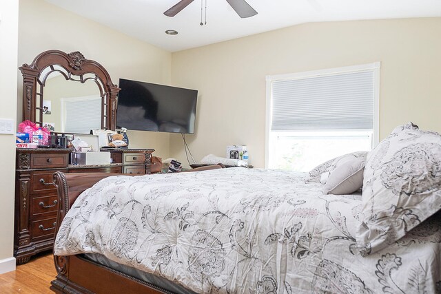 bedroom featuring light hardwood / wood-style floors, vaulted ceiling, and ceiling fan