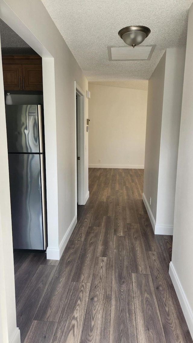 hallway featuring dark wood-type flooring and a textured ceiling