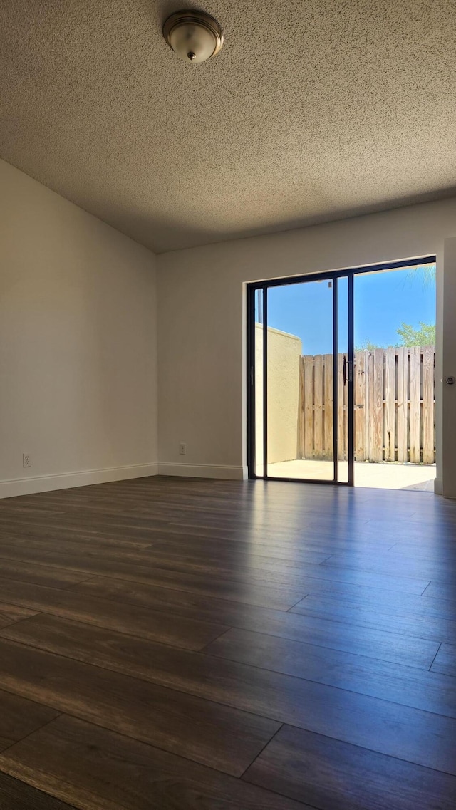 unfurnished room with dark hardwood / wood-style floors, a healthy amount of sunlight, and a textured ceiling