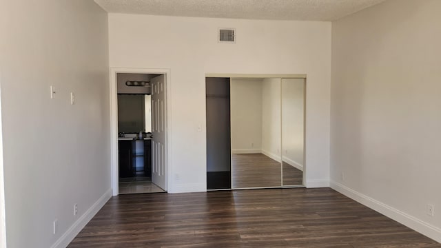 unfurnished bedroom with a closet, dark wood-type flooring, and a textured ceiling