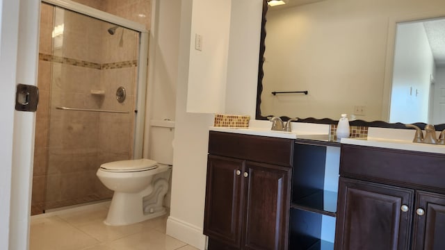 bathroom featuring tile patterned floors, vanity, toilet, and a shower with door