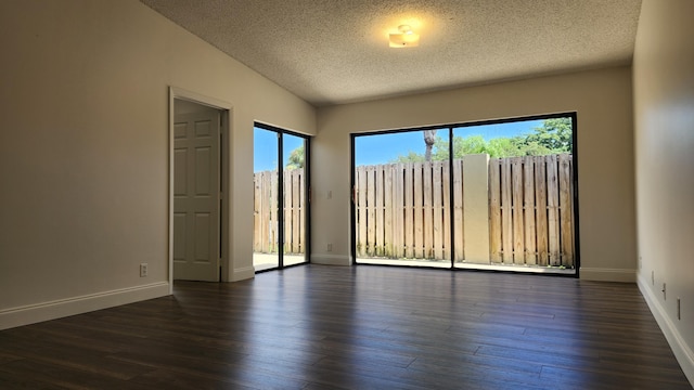 unfurnished room featuring lofted ceiling, a textured ceiling, and dark wood-type flooring