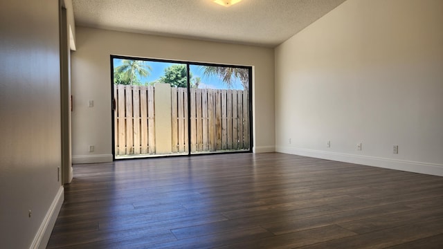 spare room with a textured ceiling and dark wood-type flooring