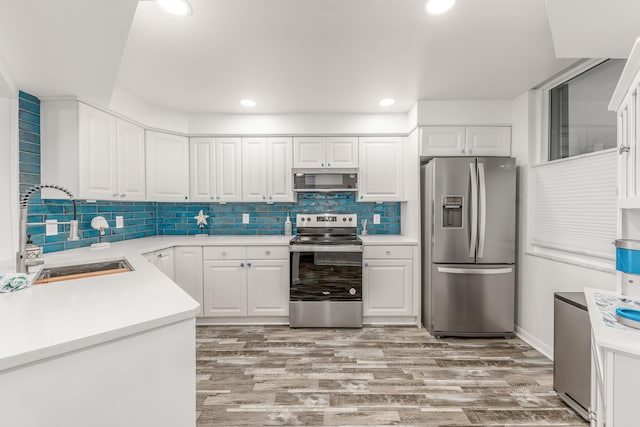 kitchen with appliances with stainless steel finishes, sink, and white cabinets