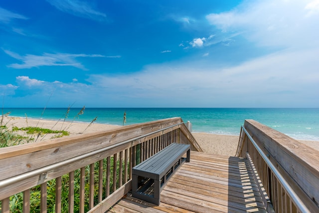 view of property's community with a water view and a beach view