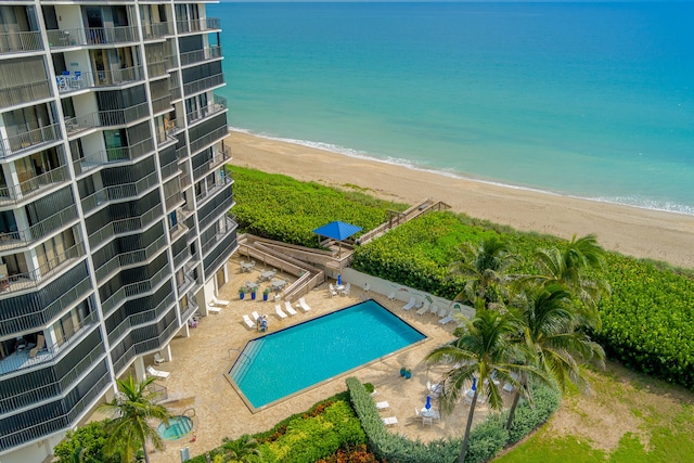 view of pool featuring a patio area, a beach view, and a water view