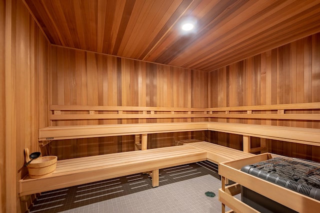 view of sauna with wood ceiling, wooden walls, and tile patterned floors