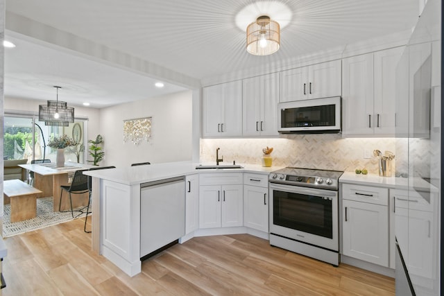 kitchen featuring light wood-type flooring, white cabinetry, stainless steel appliances, and sink