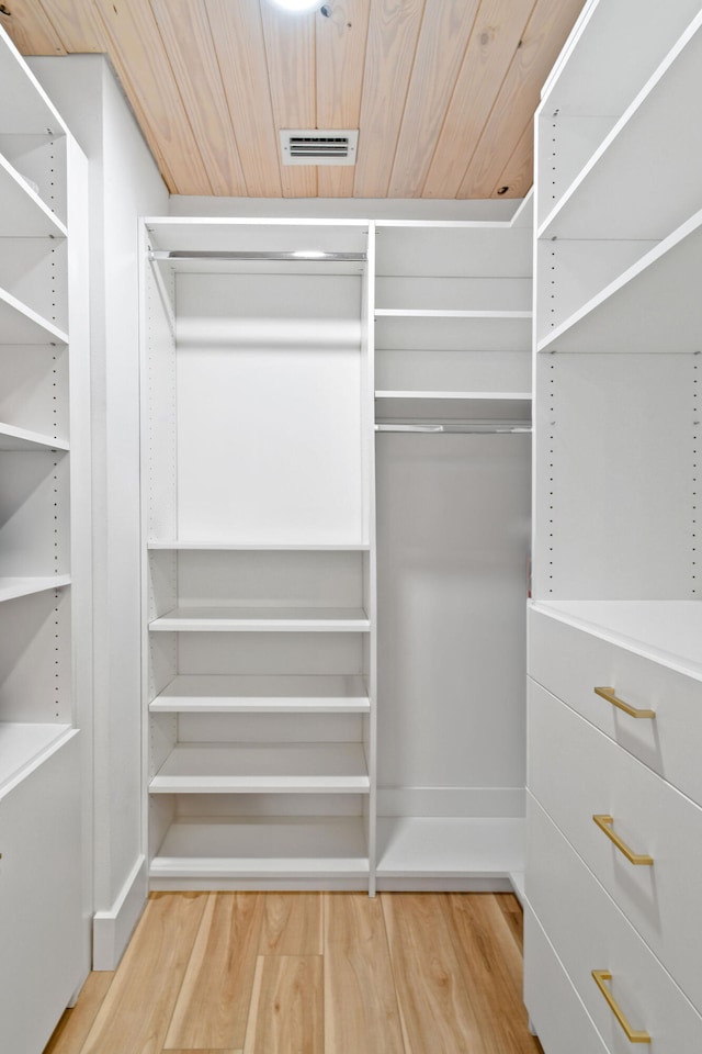 walk in closet with light hardwood / wood-style flooring