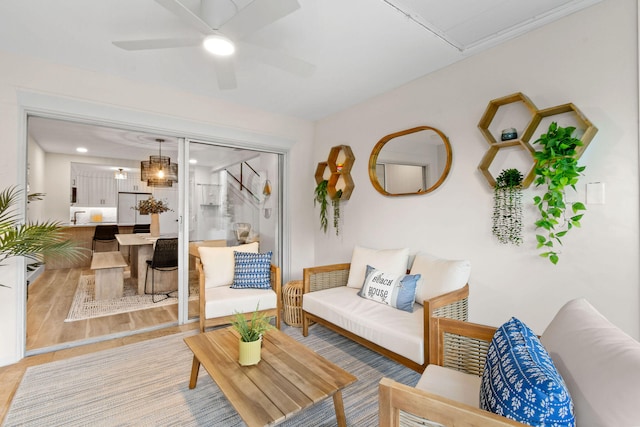 living room featuring ceiling fan and light hardwood / wood-style floors