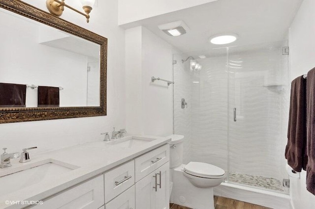 bathroom featuring a shower with shower door, toilet, hardwood / wood-style flooring, and vanity