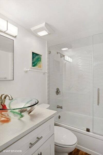 full bathroom with shower / bath combination with glass door, vanity, toilet, and wood-type flooring