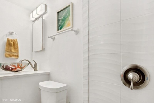 bathroom with vanity, toilet, and a shower