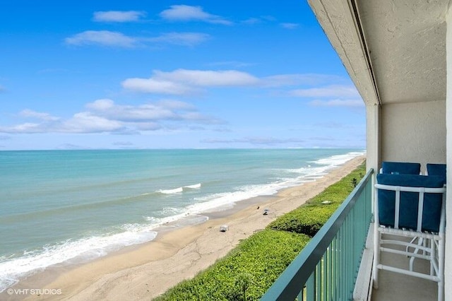 balcony with a water view and a beach view