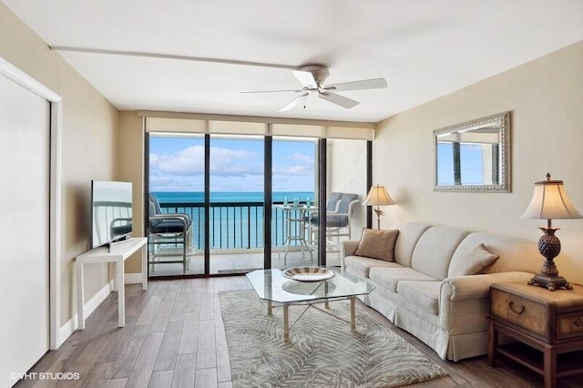 living room with floor to ceiling windows, ceiling fan, and wood-type flooring