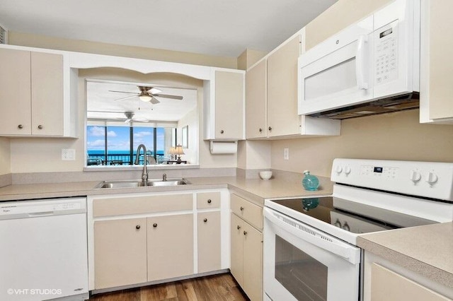 kitchen featuring wood-type flooring, ceiling fan, sink, and white appliances