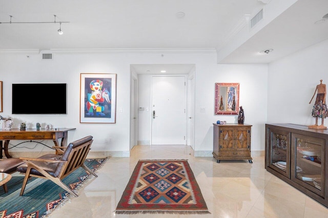 entrance foyer featuring crown molding and light tile patterned floors