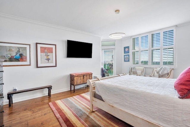 bedroom featuring wood-type flooring and ornamental molding