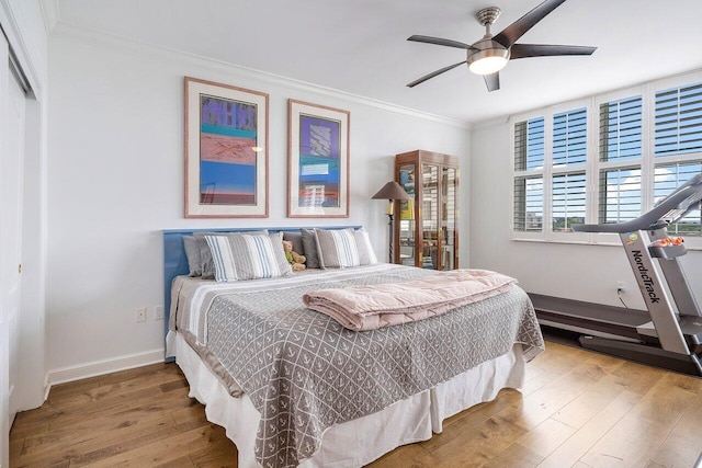 bedroom featuring crown molding, wood-type flooring, and ceiling fan