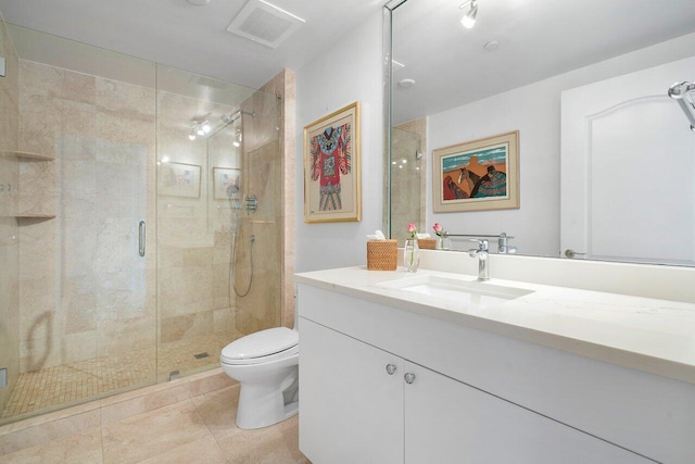 bathroom featuring tile patterned floors, vanity, a shower with shower door, and toilet