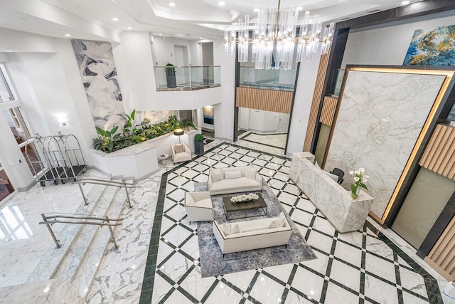 interior space with an inviting chandelier, ornamental molding, and a tray ceiling