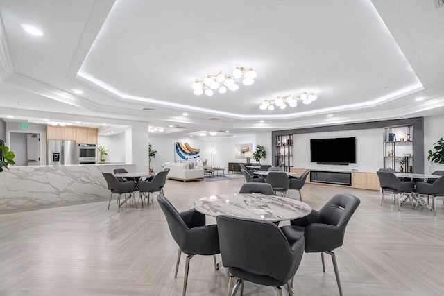 dining space featuring a raised ceiling, ornamental molding, and light parquet floors