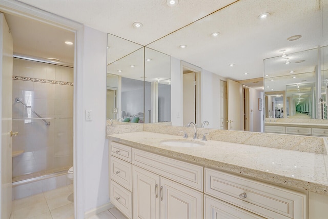 bathroom with tile patterned flooring, a textured ceiling, toilet, a shower with shower door, and vanity