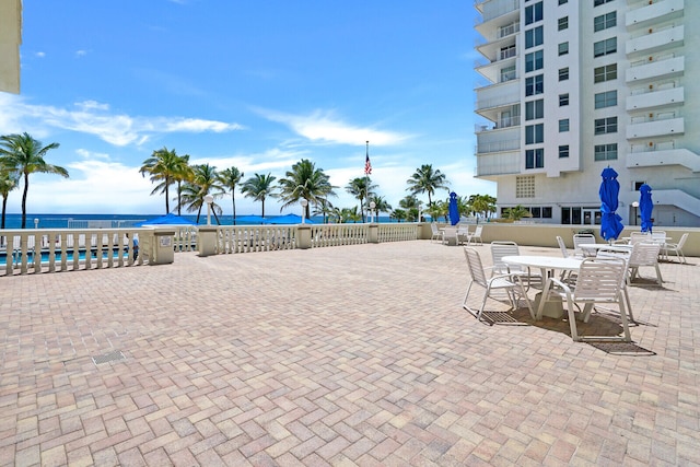 view of patio with a swimming pool and a water view