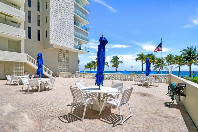 view of patio with a balcony and a water view