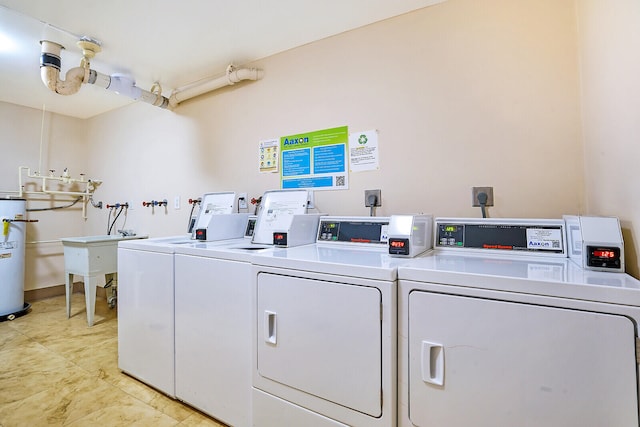 laundry area with washing machine and clothes dryer and water heater