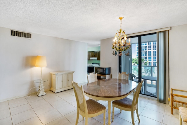 tiled dining room with a chandelier and a textured ceiling