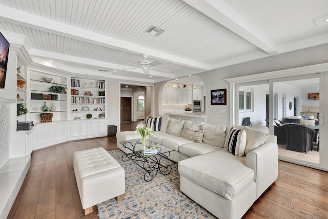 living room with light wood-type flooring, ceiling fan, and beamed ceiling