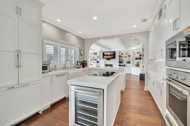 kitchen with white cabinets, wine cooler, appliances with stainless steel finishes, dark hardwood / wood-style floors, and decorative backsplash