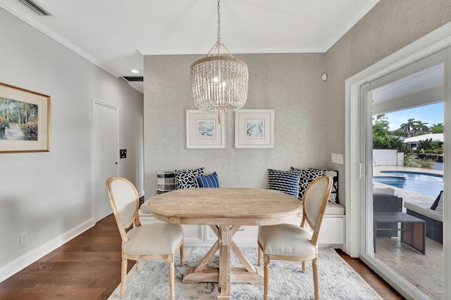 dining space featuring a notable chandelier, dark wood-type flooring, and crown molding