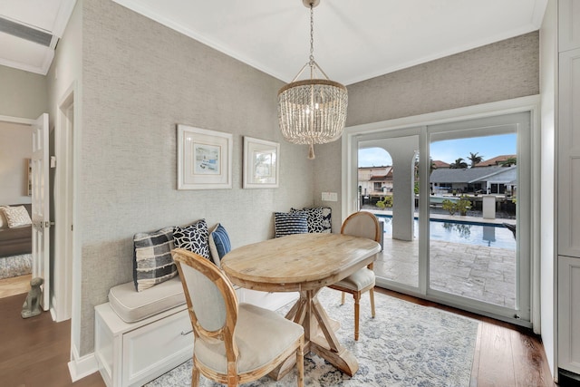 dining space with ornamental molding, dark hardwood / wood-style floors, and a chandelier