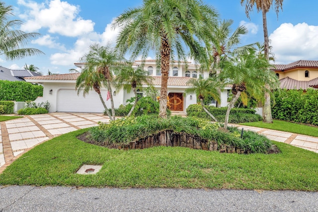 mediterranean / spanish house with a front yard and a garage