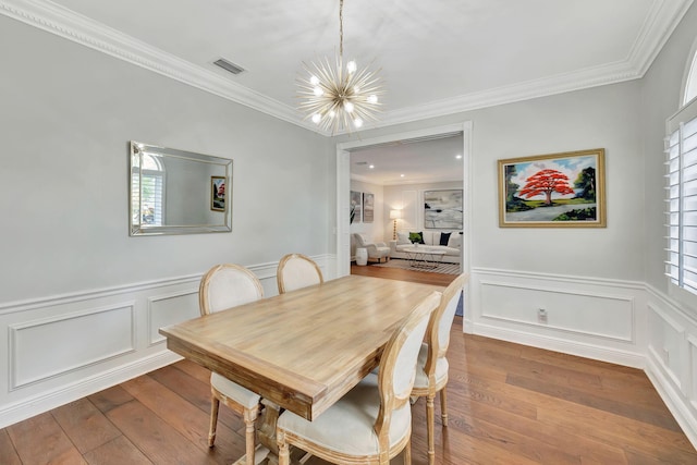 dining area featuring a wealth of natural light, wood-type flooring, and crown molding