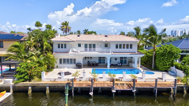 back of property featuring a balcony, a patio, and a water view