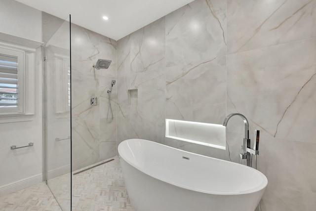 bathroom featuring shower with separate bathtub and tile walls