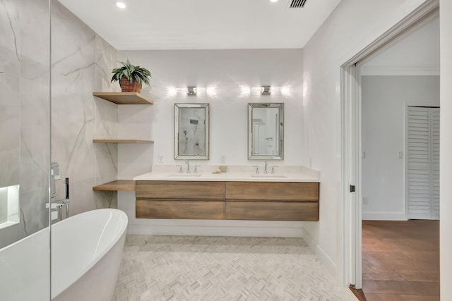 bathroom with ornamental molding, vanity, a bathing tub, and hardwood / wood-style floors