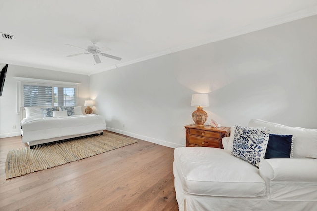 bedroom with wood-type flooring, ornamental molding, and ceiling fan