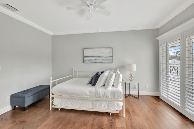 bedroom with wood-type flooring, crown molding, and ceiling fan