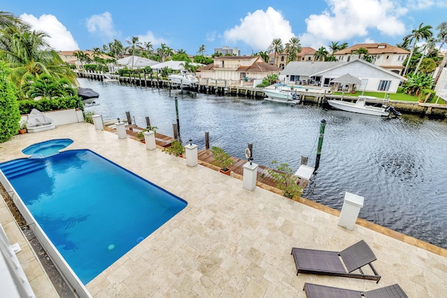 view of pool with a dock, a water view, and a patio area