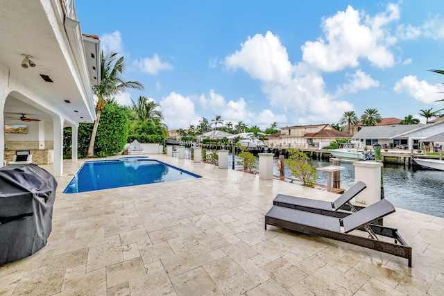 view of swimming pool featuring a patio, a water view, a dock, ceiling fan, and grilling area