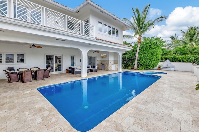 view of swimming pool featuring a patio, ceiling fan, an outdoor bar, and exterior kitchen