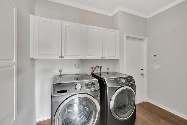 washroom featuring cabinets, washer and clothes dryer, ornamental molding, and dark hardwood / wood-style flooring