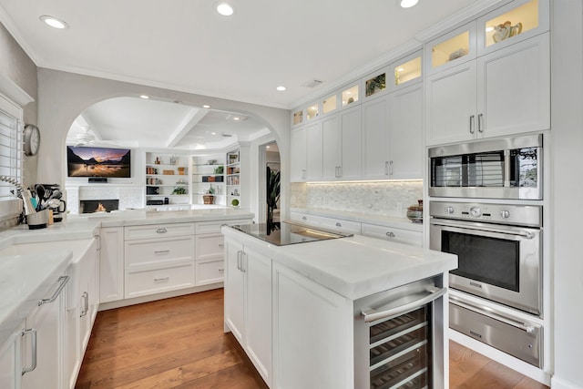 kitchen featuring white cabinetry, a center island with sink, hardwood / wood-style floors, and black electric cooktop