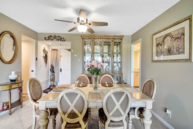 tiled dining space featuring ceiling fan and a textured ceiling