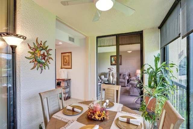 dining area featuring ceiling fan and a textured ceiling