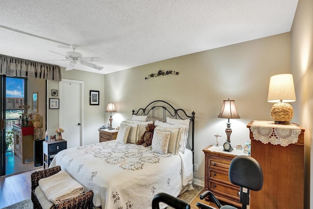 bedroom featuring hardwood / wood-style flooring, ceiling fan, a textured ceiling, and access to outside